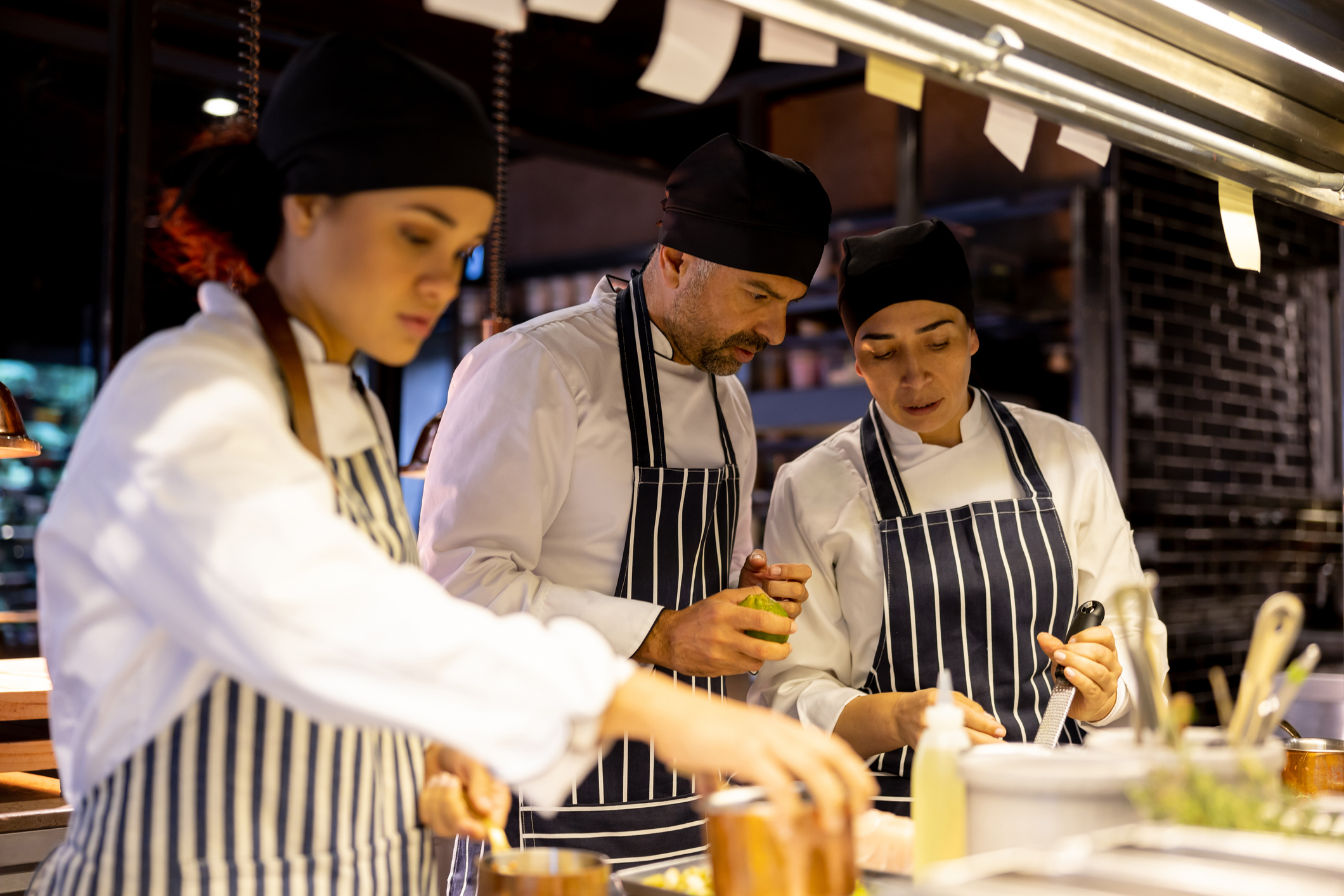 Group of chefs cooking together at a restaurant Group of chefs cooking together at a restaurant