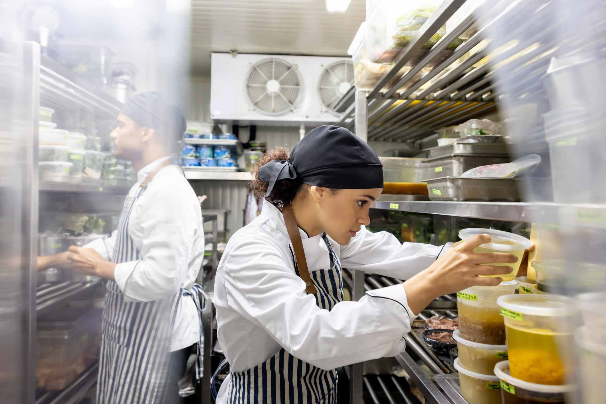 Cooks working at a restaurant and looking for ingredients in the pantry