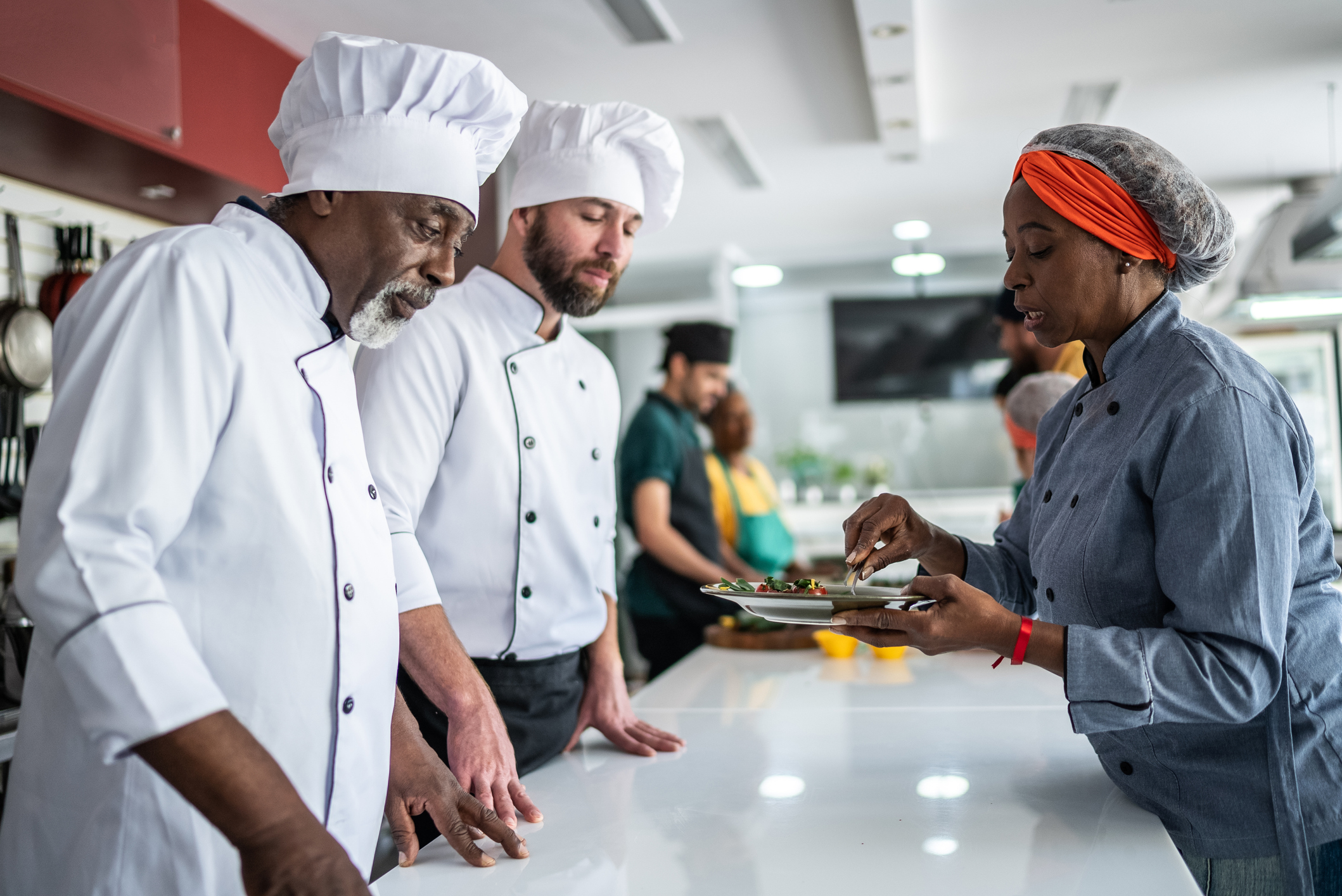 Chef analyzing food prepared by students during cooking class