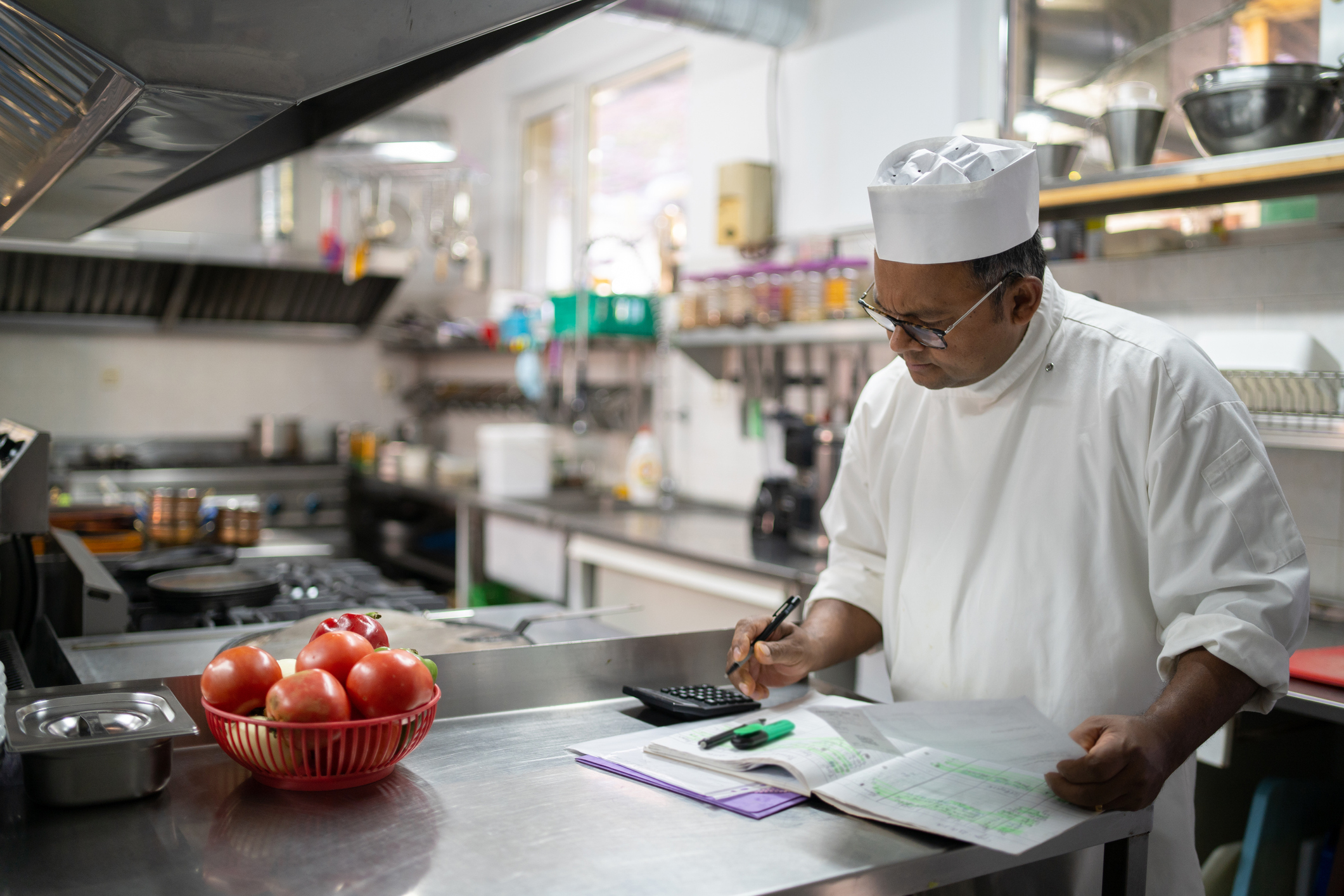 A chef calculating the kitchen expenses