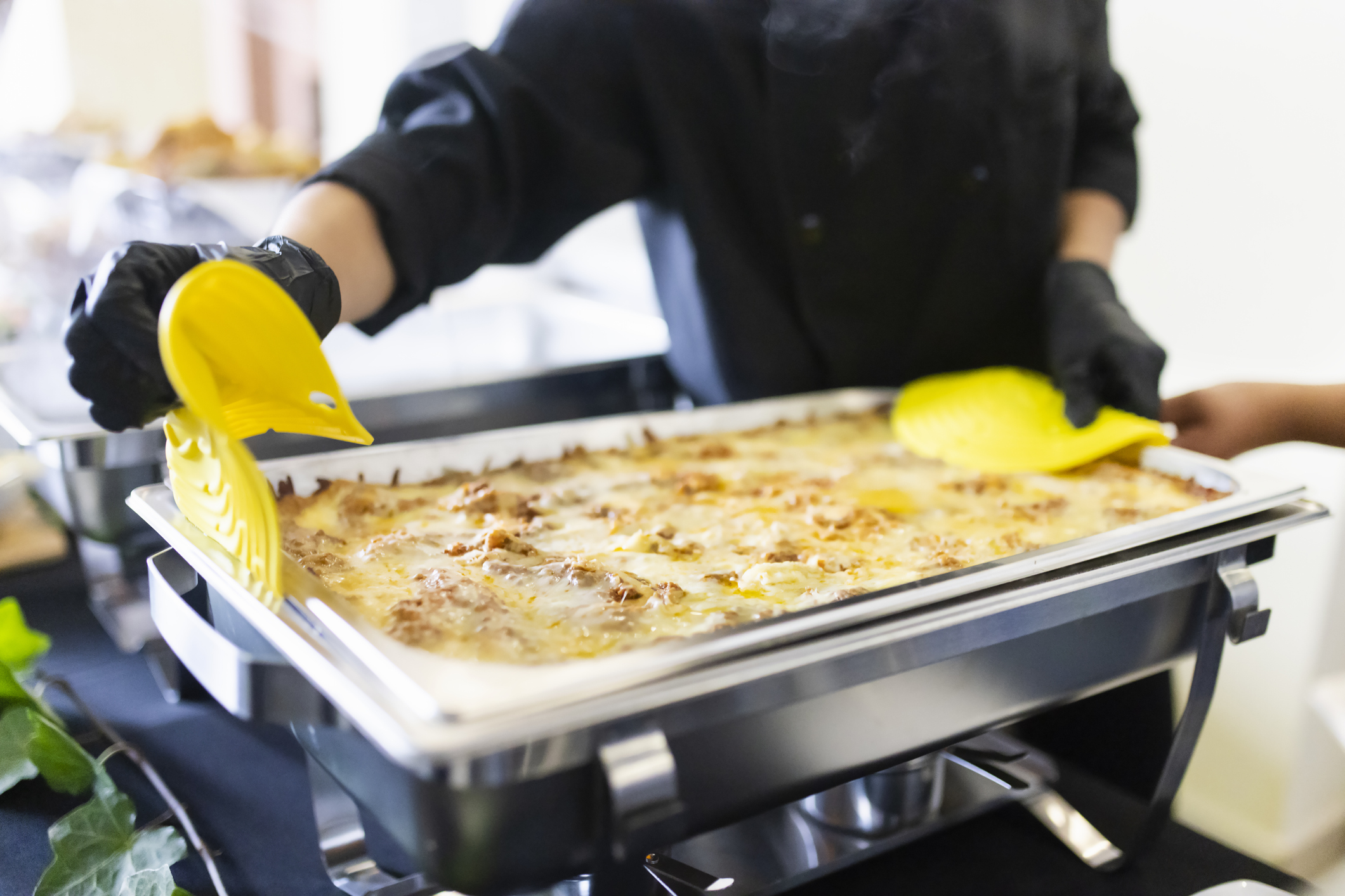 Cook arranging the buffet trays with food Cook arranging the buffet trays with food